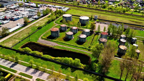 aerial flyover of water treatment tanks and silos in industrial outskirts with open roads
