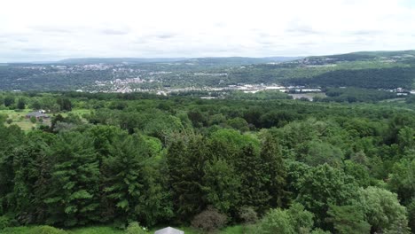 a backward dolly of the city of ithaca new york showing the valley, colleges, and lush greenery