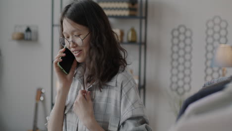 young woman talking on smartphone at home
