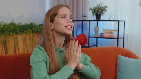 young girl praying sincerely with folded arms asking god for help, begging apology, making a wish