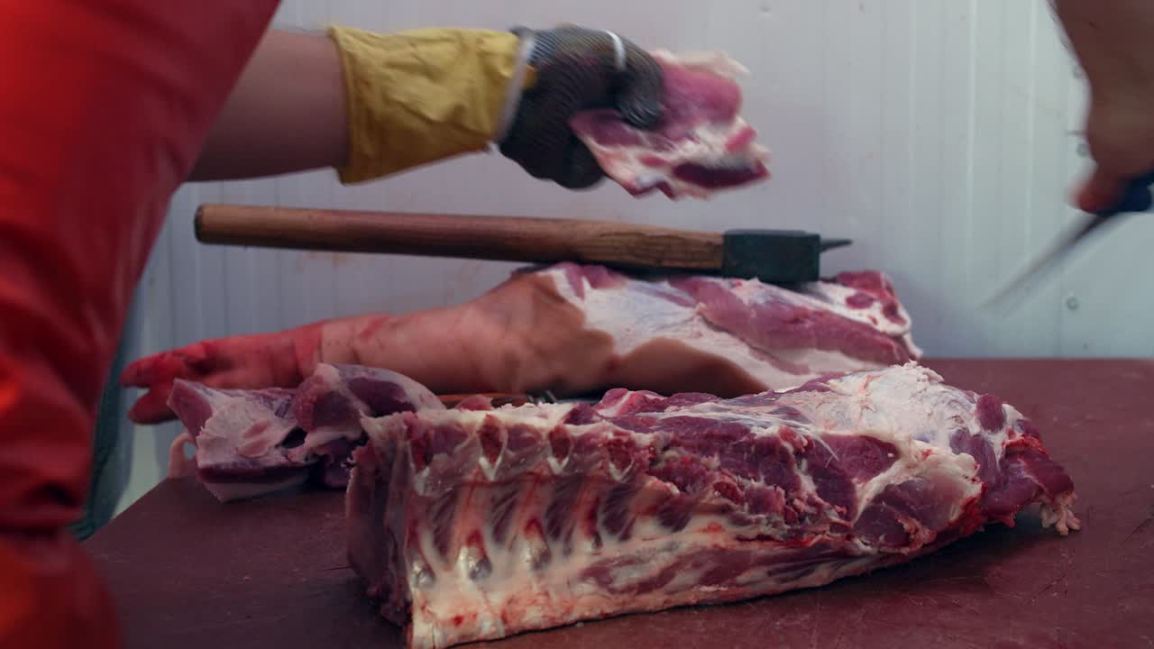 el carnicero limpia la carne del exceso de grasa y tendones con un cuchillo