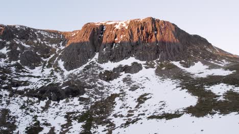 Imágenes-Aéreas-De-Drones-Que-Revelan-Un-Acantilado-Montañoso-Empinado-Y-Dramático-Y-Un-Paisaje-Salvaje-De-Páramos-En-La-Nieve-En-Invierno-Con-Rocas-Y-Rocas