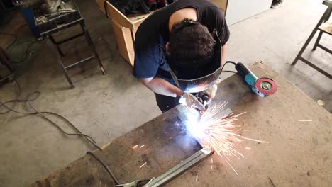 soldador en casco de protección soldado de detalles metálicos en el taller