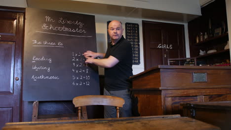 man teaching in old victorian school classroom