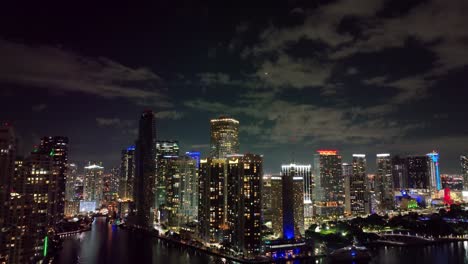 Sobre-El-Horizonte-Nocturno-De-Miami,-Un-Avión-Se-Desliza-Con-Gracia,-Acentuando-Los-Rascacielos-Iluminados-Del-Centro.