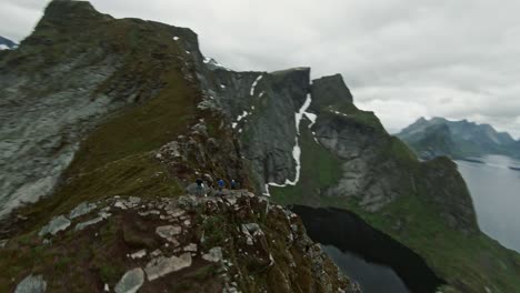 grupo de excursionistas en la cima de la alta montaña en noruega, volar alrededor de tiro fpv