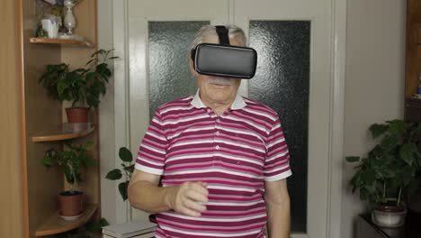 Senior-grandfather-man-in-virtual-headset-glasses-watching-3d-video-in-360-vr-helmet-at-home