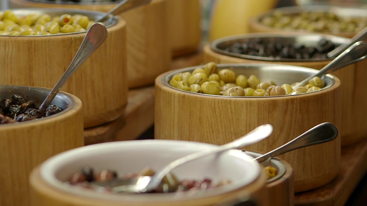 Olive assortite in ciotole di legno su un tavolo da buffet