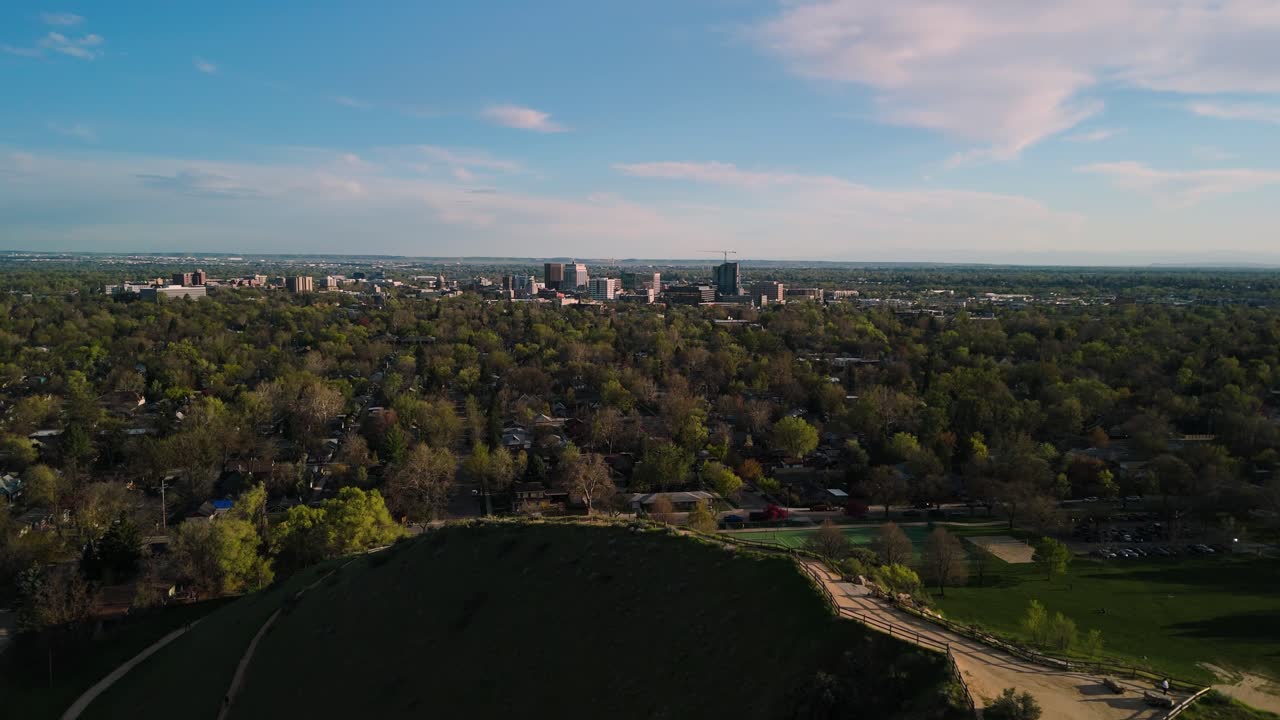 Volo di un drone sopra escursionisti e un parco con il centro di Boise in lontananza