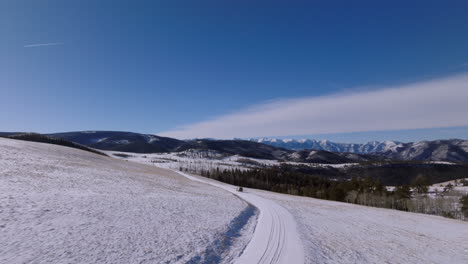 Drohnenantenne,-Die-Dem-Lieferwagen-Folgt,-Verschneite-Straße,-Berge,-Links-Abbiegen,-Colorado