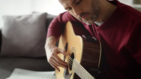 vídeo de un hombre tocando la guitarra acústica en casa