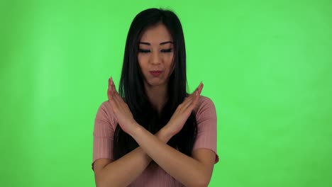 young attractive asian woman disagrees - green screen studio