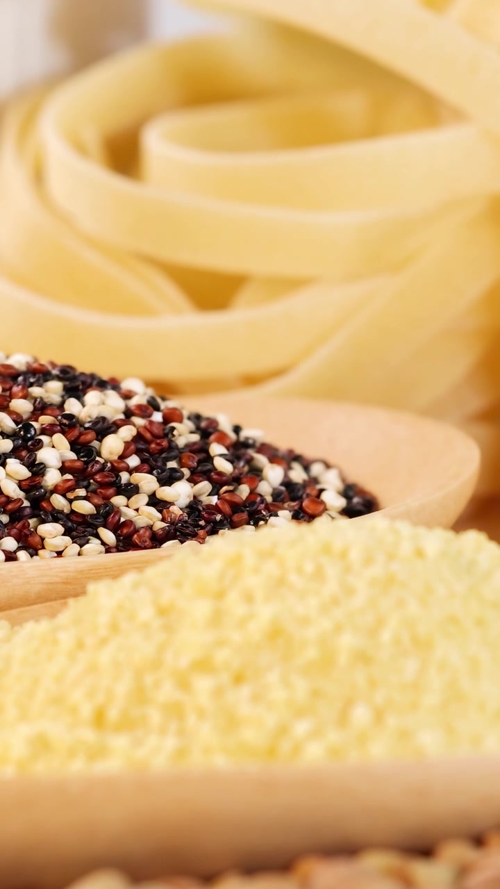En detaljeret visning af forskellige kornsorter og tagliatellepasta, der fremhæver tekstur og farve i lyse omgivelser.