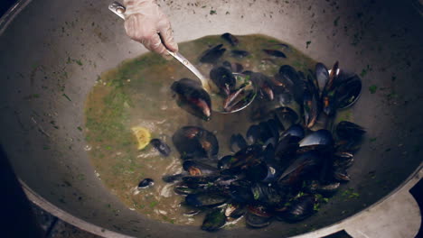 cooking mussels on pan. mussel shells cooked in pan at street food festival