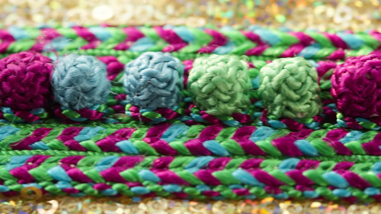 금색 반이는 직물에 뜨개질 색상 패턴과 린지 클로즈업. 축제 옷을 맞춤. 황금 반이는 반이는 배경. 새해 드레스를 는 개념