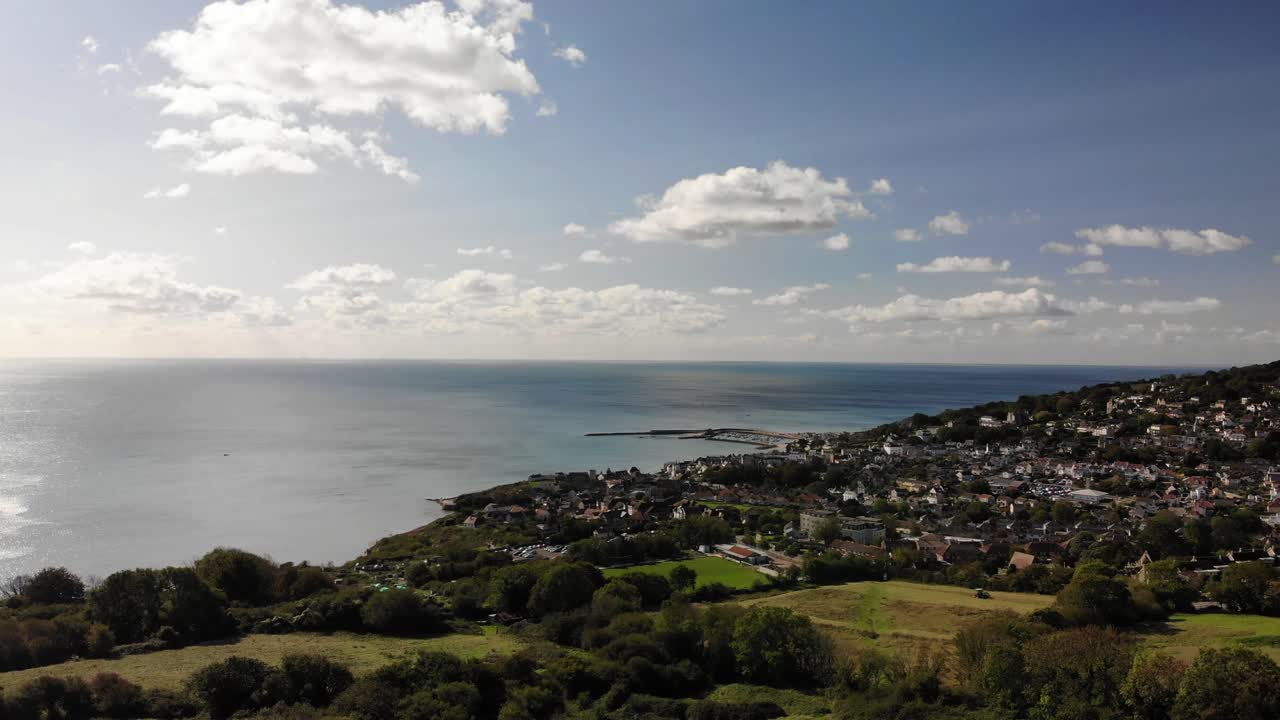 Lyme Regis Town Overlooking Calm English Channel On Sunny Day. Aerial Dolly Forward