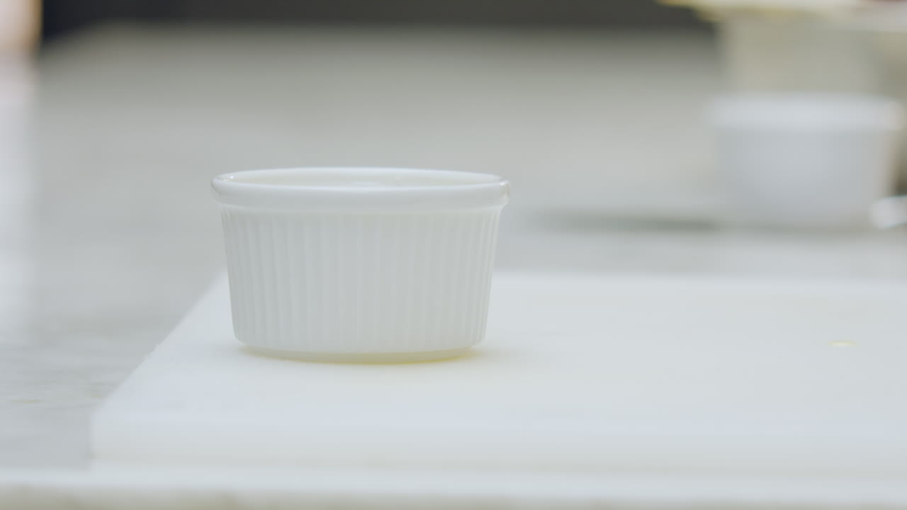 Close-up of a ceramic mold placed on a chopping board in a clean and simple kitchen environment