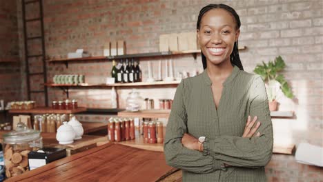 Portrait-of-happy-african-american-woman-smiling-by-counter-at-coffee-shop,-copy-space,-slow-motion