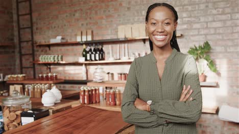portrait of happy african american woman smiling by counter at coffee shop, copy space, slow motion
