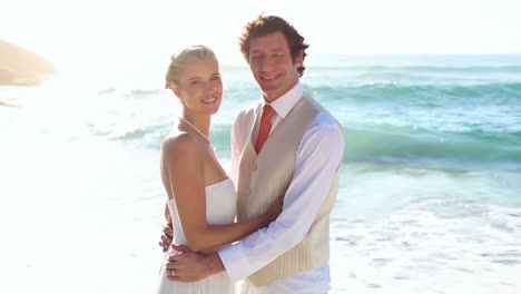 newlyweds standing face to face on the beach