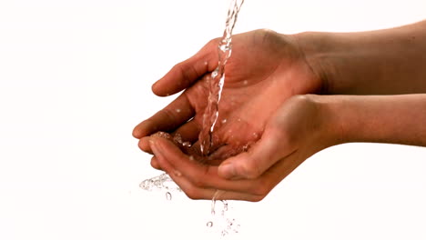 agua derramándose sobre las manos de las mujeres