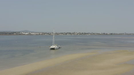 catamaran boat floating near the shore of beach in armona island, algarve, portugal