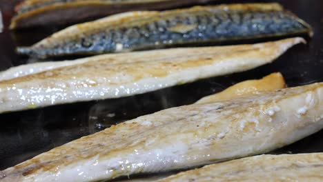 sizzling fish fillets cooking on a hot surface