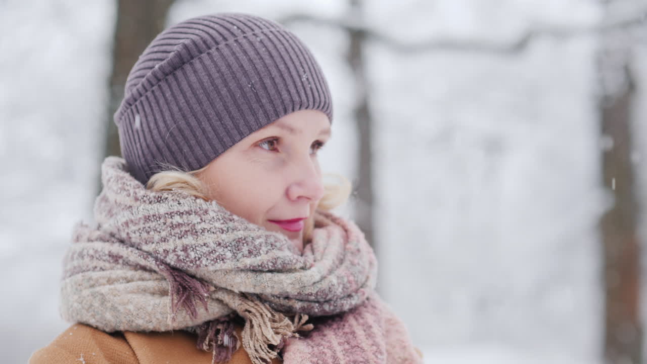 vista lateral de una mujer de mediana edad en un parque de invierno 4k video