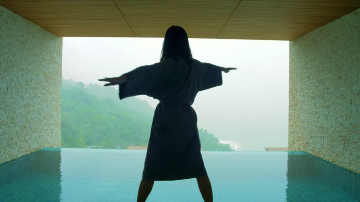 The soft and blur focus of Asia women standing and exercise on the private poolside in the resort on vacation time