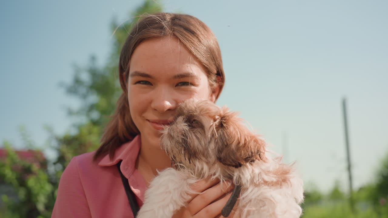 Sunlit Garden Scene With Woman And Her Puppy, Joyful Woman Gently Holds Adorable Puppy In Bright Sunlight, Woman Happily Hugs Her Young Puppy In Sunny Garden Setting Filled With Warmth