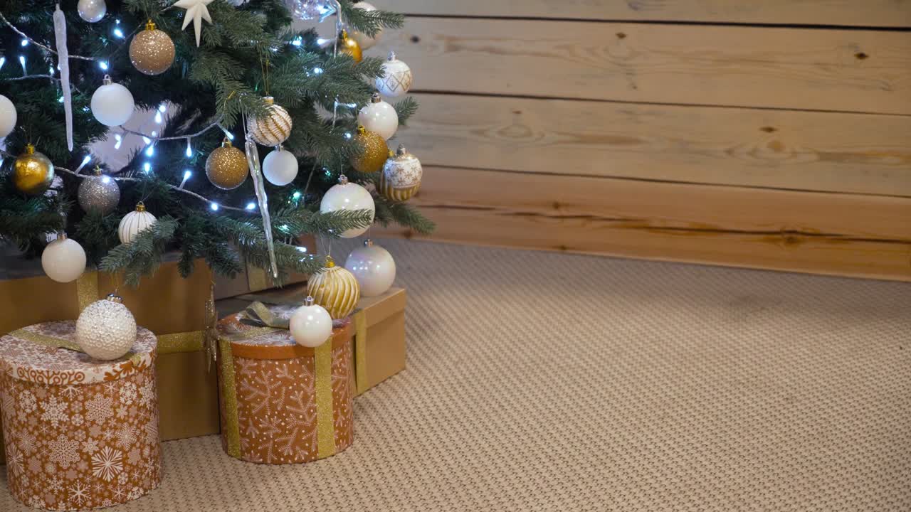gran montón de regalos y presentes al lado del árbol de navidad brillante en la sala de estar en la víspera de navidad. árbol de navidad con decoraciones e iluminación. feliz año nuevo árbol de navidades decora con bolas de vidrio blanco y dorado