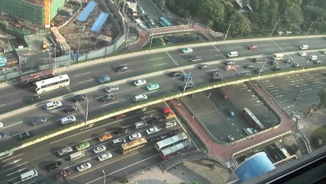 traffic flows along a freeway and city streets and pedestrians walk on the streets