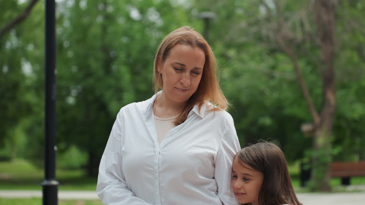 Eine Mutter umarmt ihr Kind herzlich. Die Mutter umarmt ihre Tochter liebevoll in der Natur. Sie drückt ihre Liebe aus, indem sie ihre Tochter friedlich inmitten lebendiger Pflanzen und sanften Sonnenlichts umarmt.