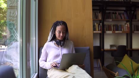 Stylischer-Student-Mit-Dreadlocks,-Der-In-Der-Bibliothek-Oder-Am-Arbeitsplatz-Am-Laptop-Arbeitet