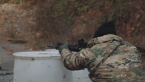 Hombre-Vestido-Con-Camuflaje-Y-Guantes-Disparando-Un-Ar-15-A-Tiro