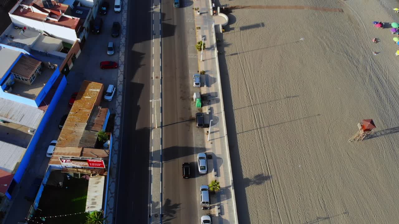 imágenes de un avión no tripulado de un coche que pasa por una carretera a lo largo de una playa en españa