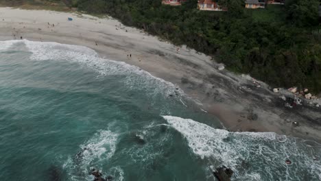 Olas-Espumosas-Salpicando-En-La-Orilla-Arenosa-De-La-Playa-En-Puerto-Escondido,-México---Toma-Aérea-De-Drones