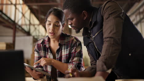 two people collaborating on a laptop in a workshop