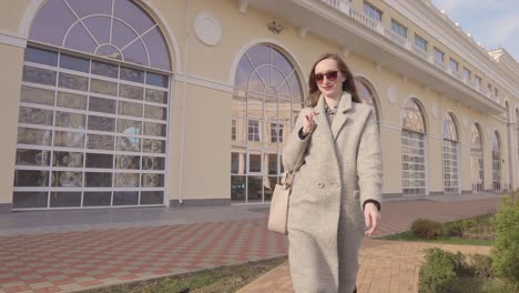 woman walking in front of a beige building