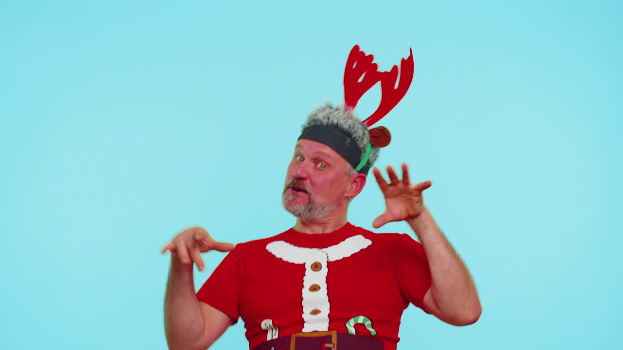 크리스마스 티셔츠를 입은 남자는 이어폰을 통해 음악을 듣고, 디스코 춤을 추며 즐거운 시간을 보내고 있습니다.