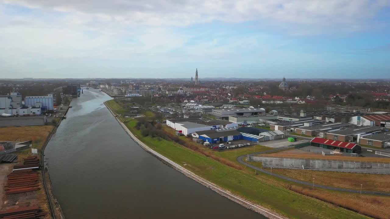 전경에 운하와 산업 지역이 있는 역사적인 도시 middelburg