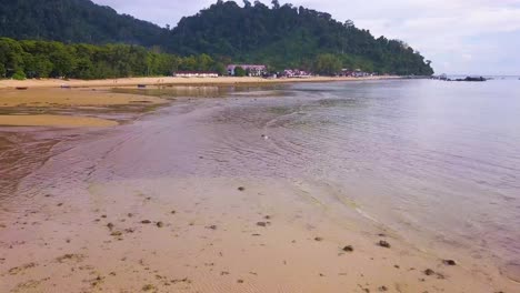 Aerial-shot-of-a-hotel-resort-near-the-beach-at-sunset-time-of-Tioman-Island,-Malaysia