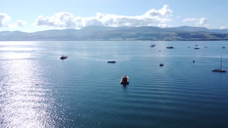 Snowdonia-clear-mountain-range-aerial-view-sunny-calm-Welsh-shimmering-seascape-push-in-shot