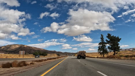 conduciendo por una carretera a través del desierto de mojave en un hermoso día -punto de vista del conductor