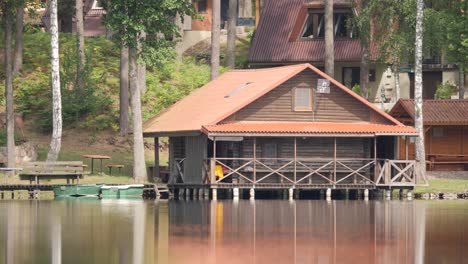 Lake-house-on-coast-with-boats,-static