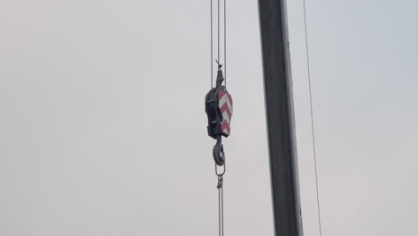 detail shot of a crane hook slowly descending to the ground