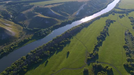 aerial view of a river valley with lush green fields and hills