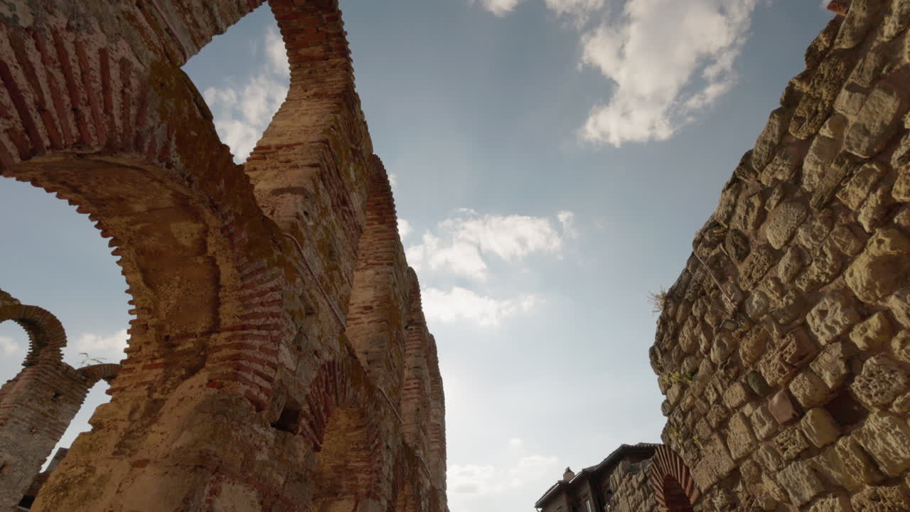 Arcos de una antigua iglesia en ruinas con luz solar y cielo en Nessebar, Bulgaria, arquitectura de piedra medieval