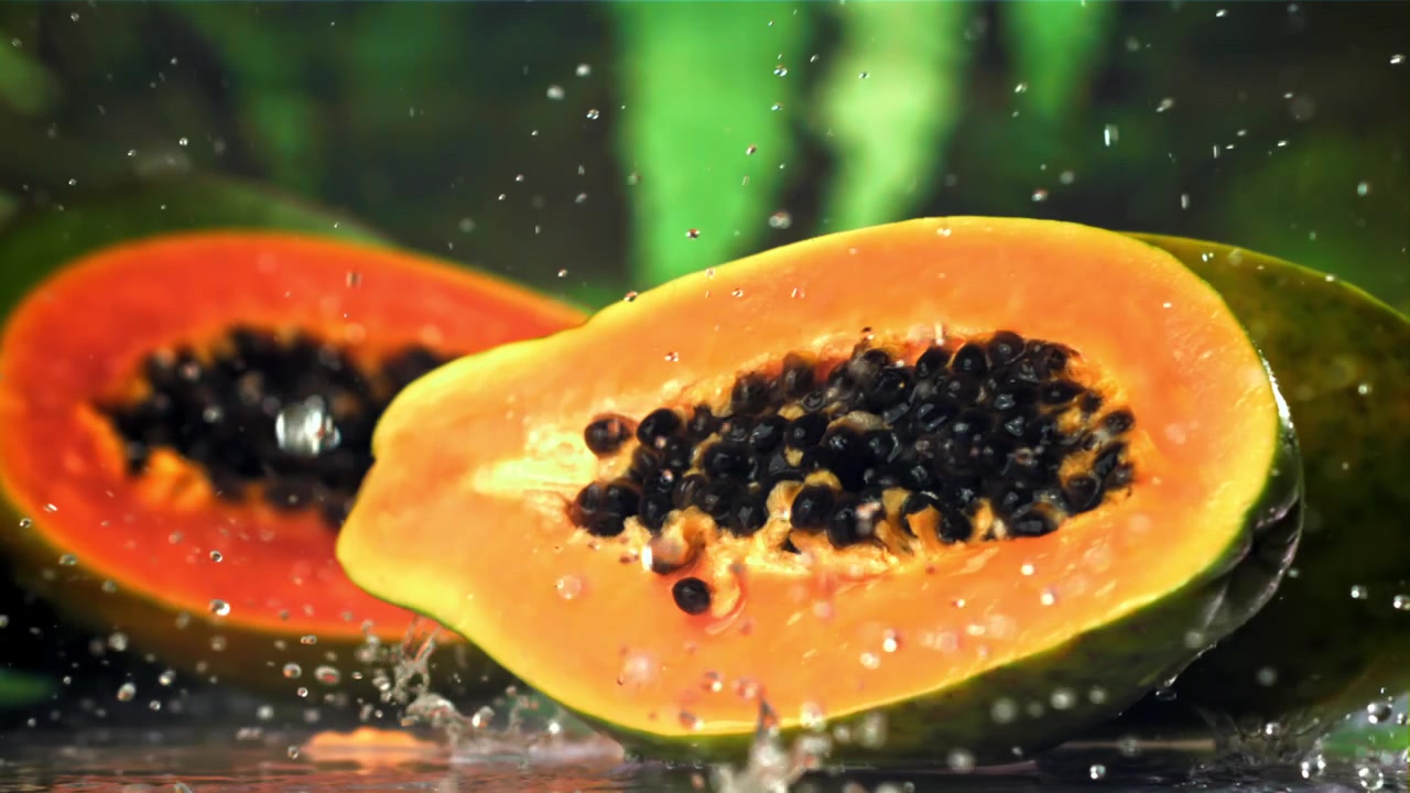 Mezze papaie vivaci con goccioline d'acqua al rallentatore