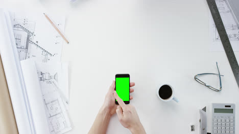 vista superior arquitecto diseñando casa conectada usando pantalla táctil de teléfono inteligente manos trabajando en el escritorio desde arriba - dragón épico rojo